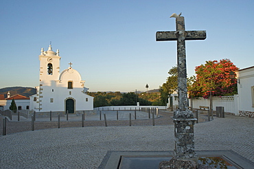 Stone cross and church at the countryside village, Querenca, Algarve, Portugal, Europe