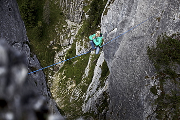 Young man balancing on a highline between two rocks, Oberammergau, Bavaria, Germany, Europe