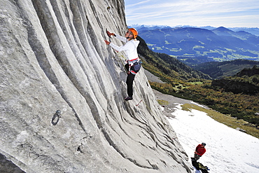 Young woman climbing while young man belaying, Multerkarwand, Treffauer, Wegscheidalm, Wilder Kaiser, Kaiser Mountain Range, Tyrol, Austria