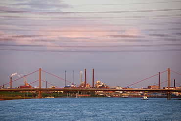 Rhine river and Bayer chemical and pharmaceutical company factory chimneys at dusk, Leverkusen, North Rhine-Westphalia, Germany, Europe