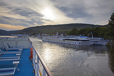 Deck of Rhine river cruise ship MS Bellevue and river cruise ships Exmeralda and Rex-Rhini alongside pier at dusk, Rudesheim am Rhein, Hesse, Germany, Europe