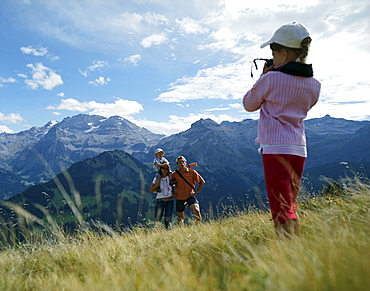 Girl photographing family, Simmental valley, Bernese Alps, Canton Bern, Switzerland