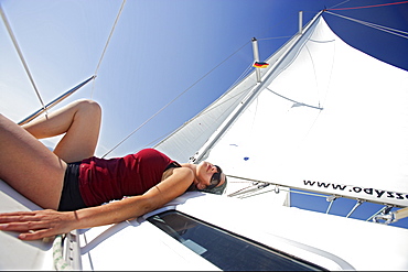 Sailing, woman sunbathing on a sailing boat