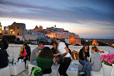 Old town of Ostuni in the evening light with cafe, Apulia, Italy