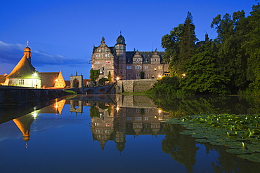 View over the pond onto Haemelschenburg castle in the evening, Emmerthal, Weser Hills, North Lower Saxony, Germany, Europe