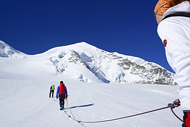 Three mountaineers ascending to Piz Palue, Grisons, Switzerland