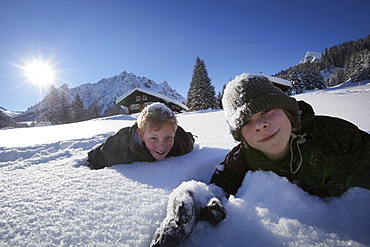 Two boys lying in snow, Gargellen, Montafon, Vorarlberg, Austria