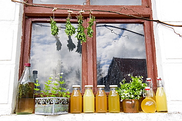 Woodruff syrup, juice and liqueur on a window sill, homemade