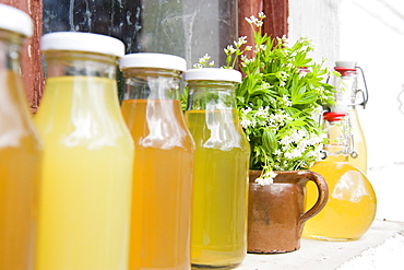 Woodruff syrup, juice and liqueur on a window sill, homemade