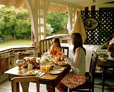 A woman and a girl having breakfast on the balcony, Rowendale Homestead, Okains Bay, Banks Peninsula, South Island, New Zealand