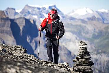 A man hiking, mountaineering at Hohtuerli, pass close to Bluemlisalphuette, Kandertal, in the background Wildstrubel and Diablerets mountains, Bernese Oberland, Canton of Bern, Switzerland