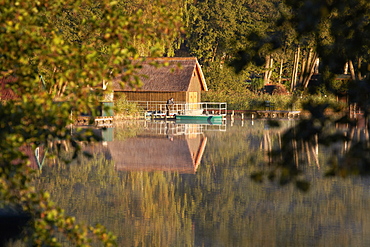 Boathouse and fisherman at Lake Krakower See, Mecklenburg Lake District, Mecklenburg Western Pomerania, Germany, Europe