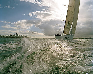 Sailing boat and backwash under clouded sky, Waitemata Harbour, Auckland, North Island, New Zealand