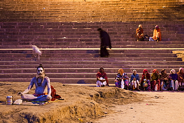 Holy man prays at Dasaswamedh Ghat alongside Ganges river at dawn, Varanasi, Uttar Pradesh, India