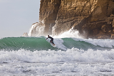 Surfer near cliffs, east coast, Castle Point, North Island, New Zealand