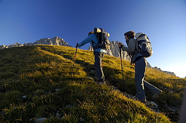 Two hikers at the ascent to Schuesselkar rock face, Tyrol, Austria, Europe