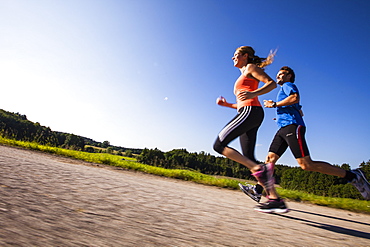 Two people jogging along a road, Upper Bavaria, Germany