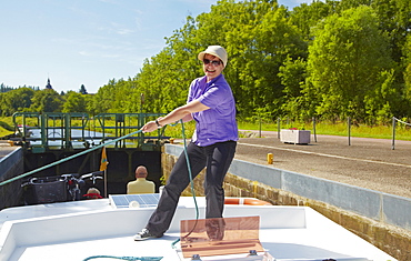 Woman on houseboat on the Canal des Houilleres de la Sarre, Lock 29, Moselle, Region Alsace Lorraine, France, Europe