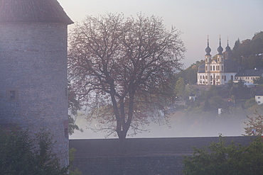 Marienberg fortress surounded by fog and Capuchin cloister Kaeppele, Wuerzburg, Bavaria, Germany