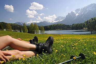 Couple hiking at Lautersee, having a rest, Mittenwald, View towards Karwendel Mountain Range, Upper Bavaria, Bavaria, Germany, Europe