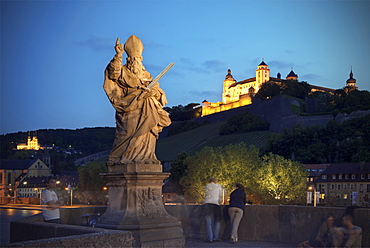 Statue on the old Main Bridge with view of Marienberg fortress at night, Wuerzburg, Franconia, Bavaria, Germany