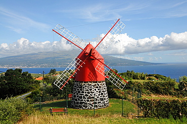 Windmill over Praia do Almoxarife with Pico Vulcano in the background, Island of Faial, Azores, Portugal