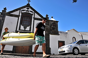 Two teenagers carrying canoes, In Santa Cruz, Island of Graciosa, Azores, Portugal