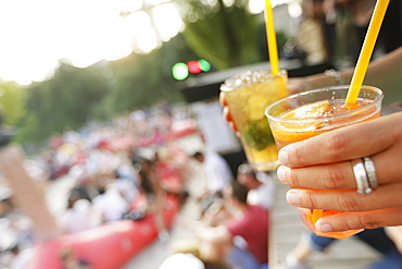 Woman holding drinks, Kulturstrand at Corneliusbruecke, Munich, Bavaria, Germany