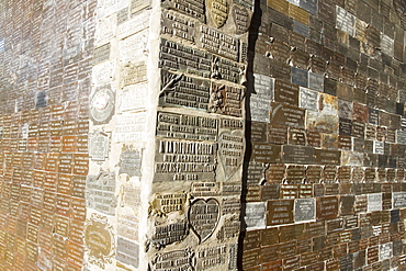 Thanksgiving plaques on a shrine at the Difunta Correa Sanctuary, Vallecito, San Juan, Argentina. La Difunta Correa is the most popular of Argentina's folk saints. She was a woman whose husband was forcibly recruited around the year 1840, during the Argentine civil wars. Becoming sick, he was then abandoned by partisans. In an attempt to reach her sick husband, Deolinda took her baby and followed the tracks of the partisans through the desert of San Juan Province. When her supplies ran out, she died. Her body was found days later by gauchos, however they found the baby still alive, feeding from the deceased woman's miraculously ever-full breast. Once the folk tale became known, her devout followers believe her to perform miracles and intercede for the living. Cattle keepers and truck drivers create small altars throughout Argentina and leave bottles of water as votive offerings.