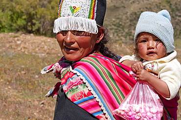 Tarabuco woman carrying girl, Jatun Yampara Indigenous Community, Chuquisaca Department, Bolivia