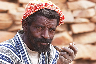 Dogon man smoking a pipe in Tireli, Mali