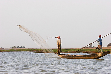 Fisherman throwing a net into the Niger River between Mopti and Lake DâˆšÂ©bo, Mali