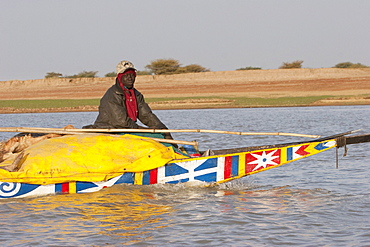 Man on a boat on the Niger River between Lake DâˆšÂ©bo and Sebi, Mali