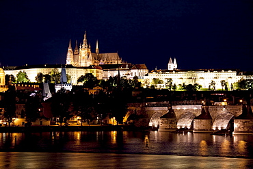 Charles Bridge and Prague Castle reflected in the Vltava river at night, Prague, Czech Republic