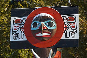 Moon on Chief Skedans Mortuary Pole carved in Haida style by Bill Reid with Werner True covered in snow in Stanley Park, Vancouver, British Columbia, Canada