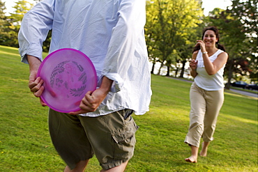 Couple Playing Frisbee in Park