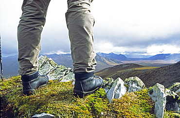 View of Hikers Boots Standing on a Mountain Ridge, Overlooking the Dempster Highway, Yukon