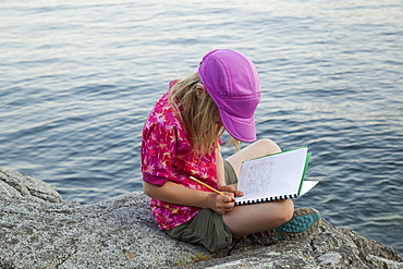 Grade 3 girl taking notes during a school outing, Keats Island, British Columbia