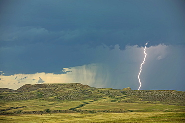 Digitally enhanced image with painterly effect of lightning striking over 70 Mile Butte and Sleeping Lion Butte, Grasslands National Park, Saskatchewan