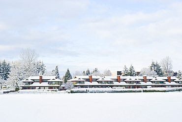 Lakeside town homes with red chimneys covered with freshly fallen snow. Mill Lake, Abbotsford, British Columbia