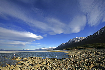 Woman Standing on Rocks along Kluane Lake under Lenticular Clouds, Yukon