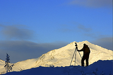 Photographer Silhouetted against the Ogilvie Mountains near the Dempster Highway, Tombstone Territorial Park, Dawson City, Yukon