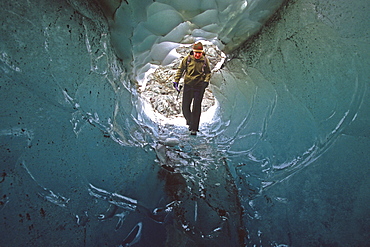 Hiker Exploring a Small Ice Cave, Llewellyn Glacier, Atlin, British Columbia