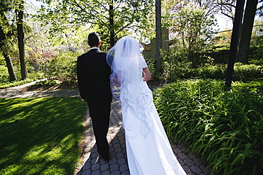 Couple on their Wedding Day Walking down a Path in a Park
