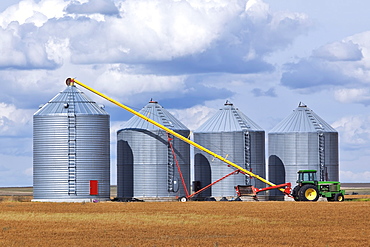 Grain auger and tractor ready to fill silo, Assiniboia, Saskatchewan