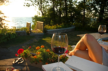 Woman's Legs on Deck Chair with Wine Glasses, Lake Simcoe, Ontario