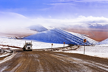 Truck driving on Dempster Highway and fog over Richardson Mountains, Yukon