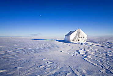 Ice fishing tent at sunset on frozen Lake Winnipeg, near Gimli, Manitoba