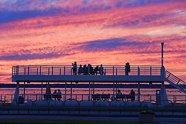 Artist's Choice: People looking out at St. Lawrence River and Saint-Barnabe Island at dusk, Bas-Saint-Laurent region, Rimouski, Quebec