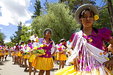 Girls carrying festive baskets in the Entrada de Comadritas parade during the Carnaval Chapaco, Tarija, Bolivia